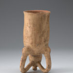 Underside view of ceramic drinking vessel resembling a piglike animal, positioned upright on its front arms and snout.
