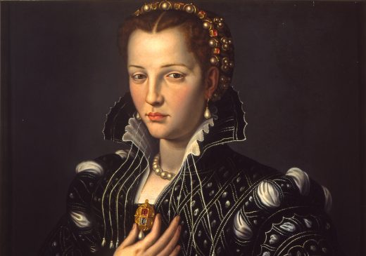 An oil painting of a woman wearing a black dress adorned with jewels and holding a gold pendant in her right hand. The background is dark gray, and there is a wooden table in the foreground, in the bottom right corner.