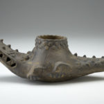 Side view of a brown crocodile-shaped ceramic vessel.