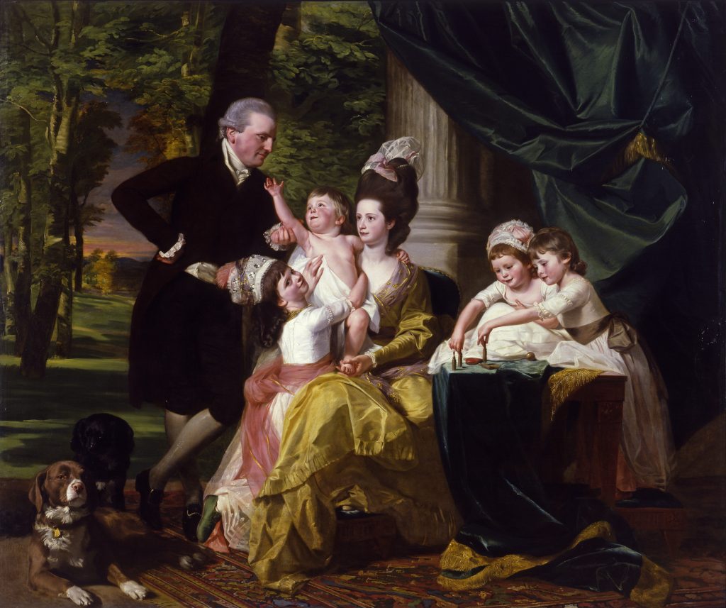 A large portrait of a family of six people posing in front of a green field, with trees on the left and a marble column and blue drapery on the right. The man stands on the left, gazing toward his seated wife, who holds the youngest child on her lap. The three other children are grouped around their mother. Two of them play with game pieces on a table on the right. There are two dogs in the bottom left corner.