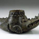 Un recipiente de cerámica con forma de cocodrilo.