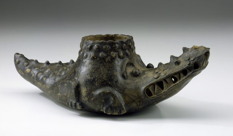 A brown crocodile-shaped ceramic vessel with a round opening on its back.