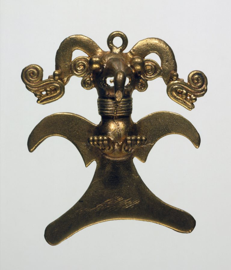 A symmetrical gold metal pendant of an eagle in flight with wings spread, wearing an ornate, two-headed snake headdress.