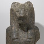 A granite sculpture of the upper torso, chest, and shoulders of a woman and the head of a lioness.