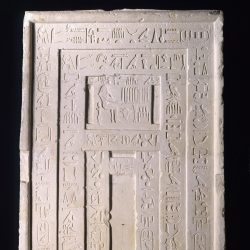 A sculpture of a stone door with hieroglyphic carvings.