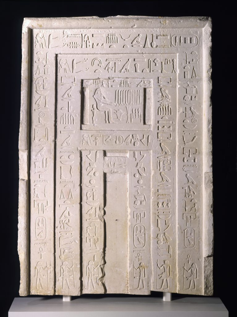 A sculpture of a stone door with hieroglyphic carvings.
