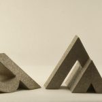 Una imagen de nueve esculturas tridimensionales de cartón de la letra A dispuestas en línea.