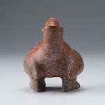 Back view of a reddish-brown ceramic vessel shaped like a parrot.