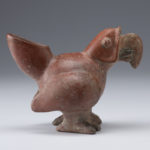 Side view of a reddish-brown ceramic vessel shaped like a parrot.