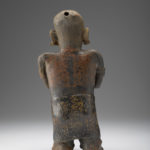 Back of ceramic figure of a woman.
