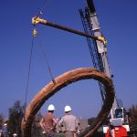 Crane pulls a ring of Gyre out of the ground.