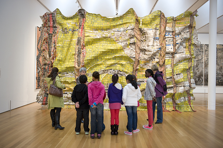 Tour group in front of Lines that Link Humanity by El Anatsui at the NCMA
