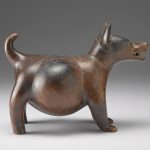 Side view of a brown and red ceramic sculpture shaped like a dog.