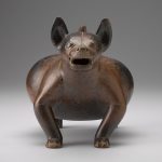 Front view of a brown and red ceramic sculpture shaped like a dog.