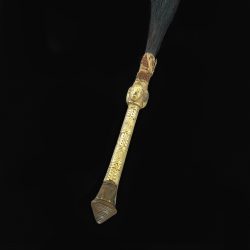 wooden handle of a flywhisk covered in gold leaf with patterns
