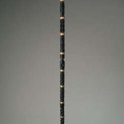 five foot tall black staff with small gold foil sculpture on top