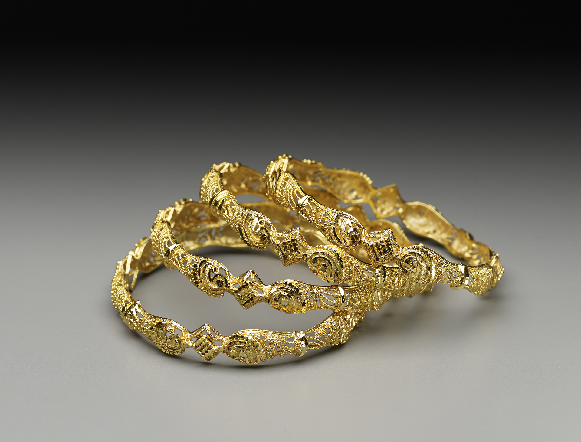 Stacking bracelet set Four gold- plated bracelets stacked on top of each other and leaning to the right