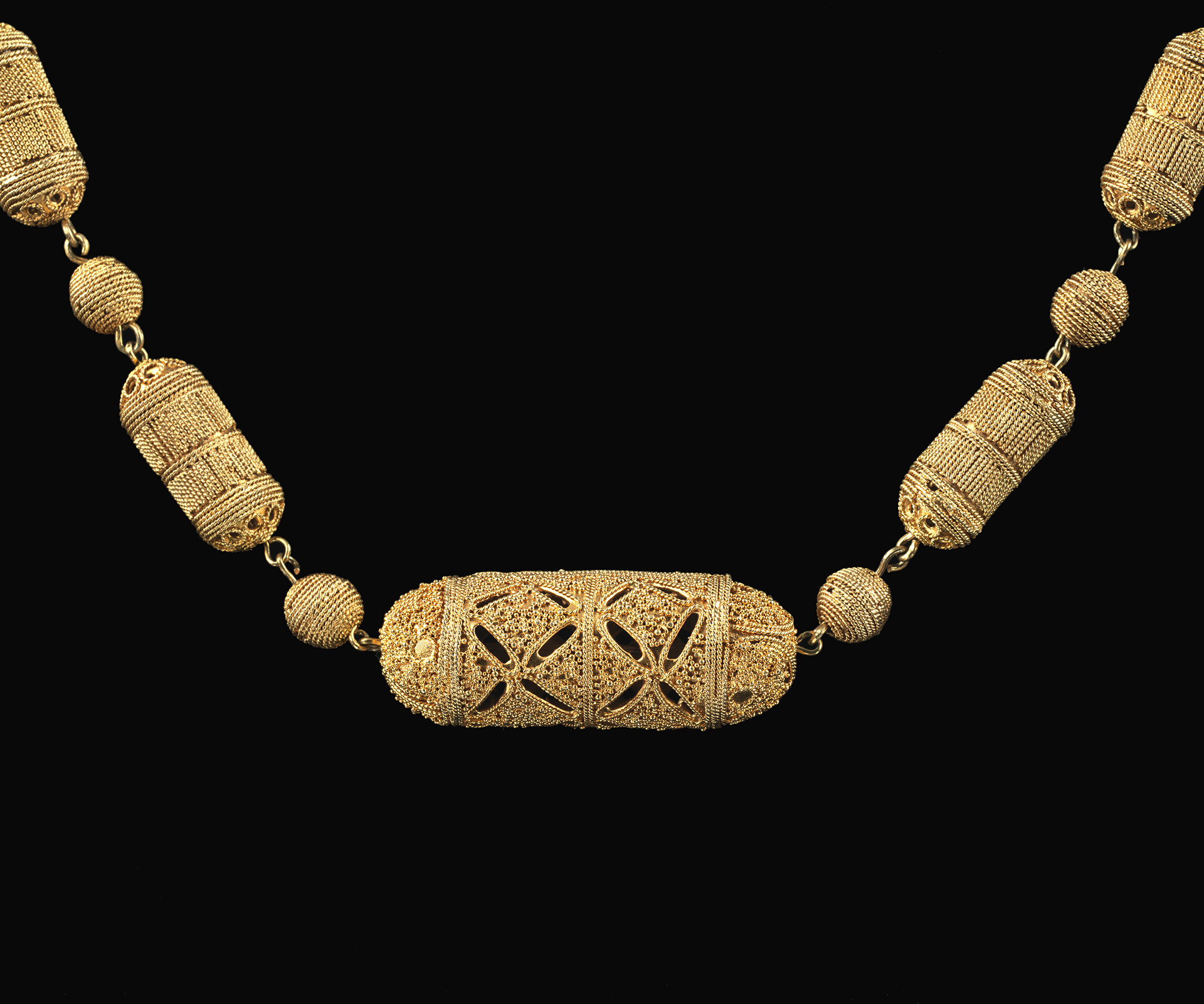 Senegal Necklace (Close Up) Close up image of gold necklace with cylinder beads