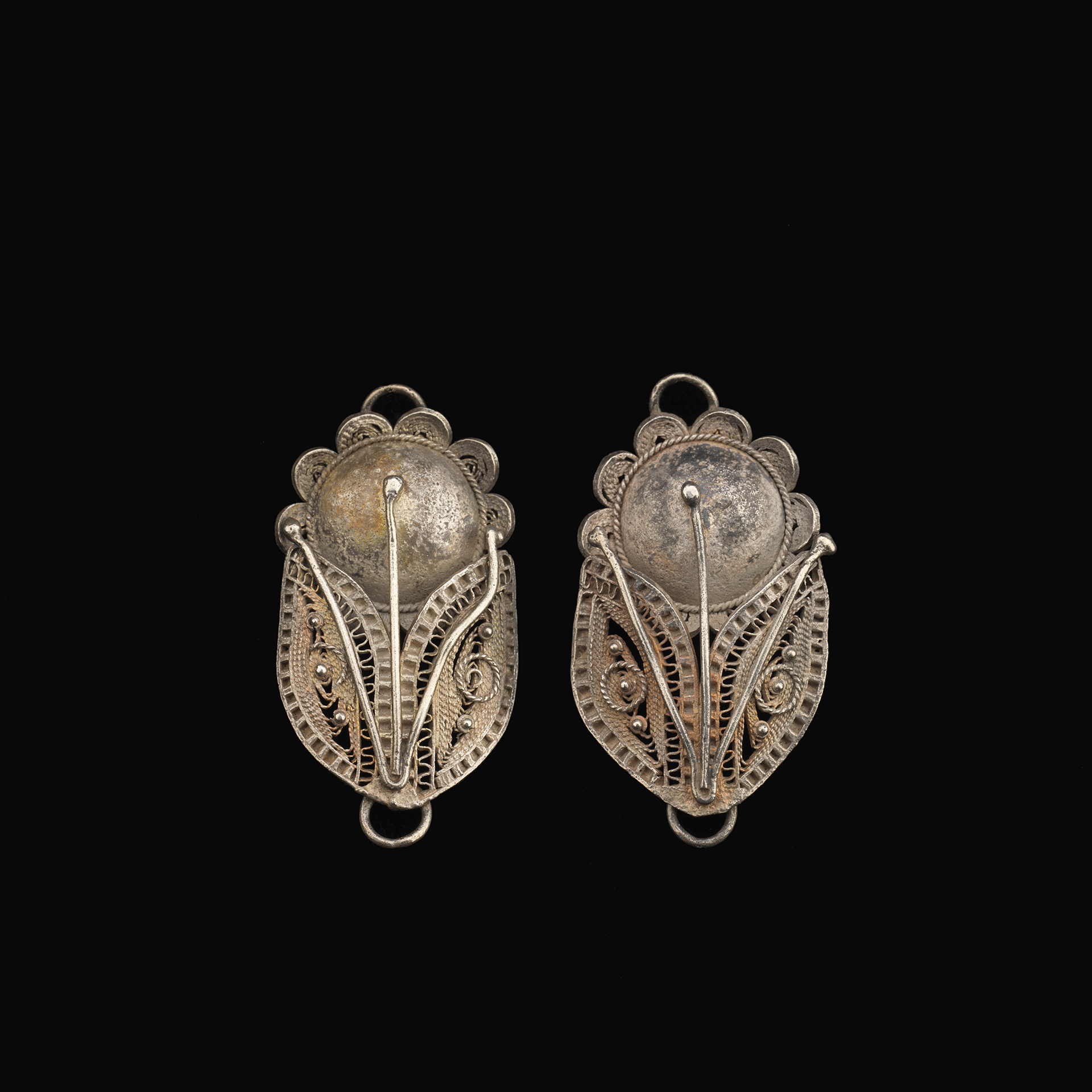 Pendants Two oval pendants with a flower at the top and stem and leaves at the bottom