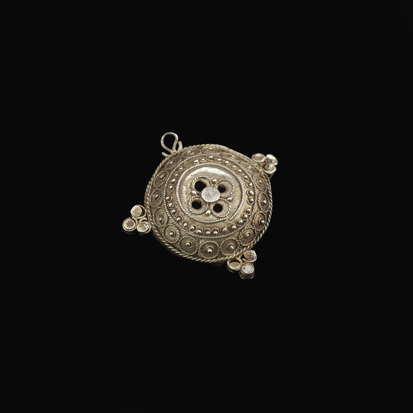 Hair ornament a circular hair ornament with a cross design on it