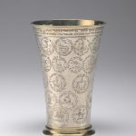 A silver, horn-shaped banquet cup that is engraved with the names of the members of a burial society’s members and their personal emblems.