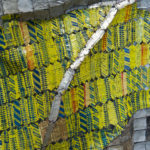 Detail view of large mixed media sculpture made of multicolored, interconnected metal pieces.