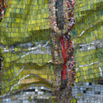 Detail view of large mixed media sculpture made of multicolored, interconnected metal pieces.