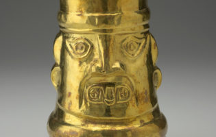 Una copa de oro decorada con la cara de un dios peruano.