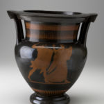 A black vase featuring red-colored male and female figures. The figures depict the ancient Greek god Poseidon chasing a young woman on one side of the vase and a woman running away from him on the other side.