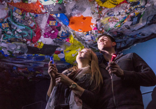 visitors look up at a work of art made from reclaimed plastics