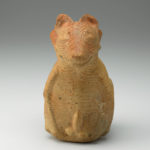Front view of ceramic vessel shaped like a hairless dog.
