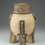 Rear view of a painted terracotta vessel shaped like a crouching animal.