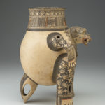 Side view of a painted terracotta vessel shaped like a crouching animal.