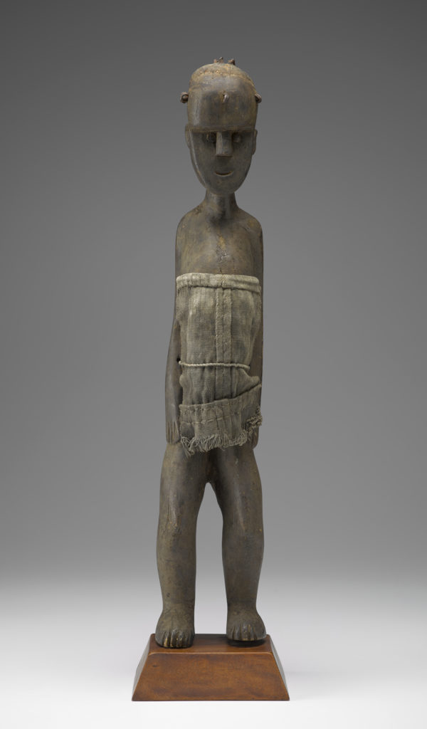 A small wooden sculpture of a woman with most of her torso covered by a burlap cloth. Front view.