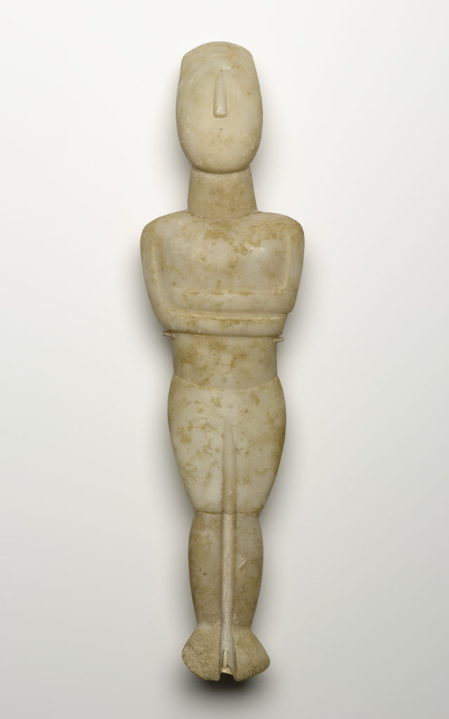 Escultura de mármol blanco de una figura femenina reclinada con los brazos cruzados bajo el pecho, sobre un fondo blanco sólido.