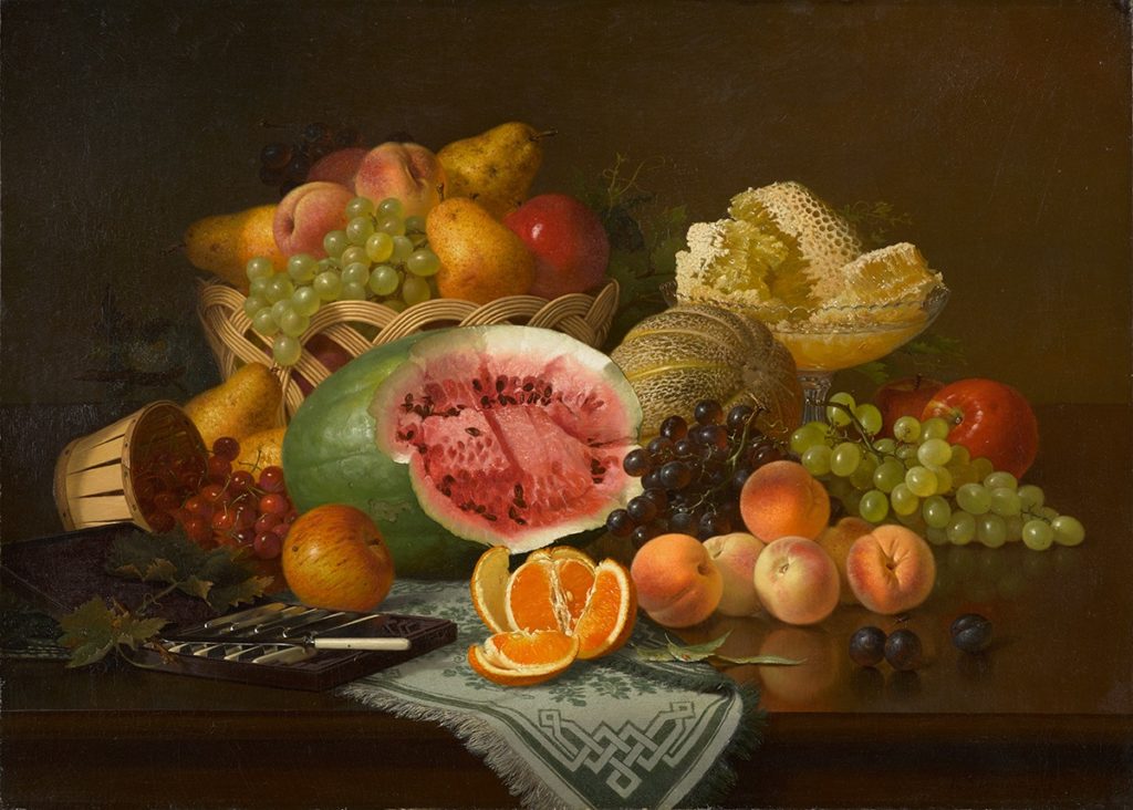 An oil painting of a watermelon, peaches, oranges, grapes, pears, and other fruit displayed on a wooden table. There is a glass bowl filled with pieces of a honeycomb on the right. On the left there is a set of knives with white handles.