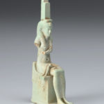 A small sculpture of the Egyptian goddess Isis with remnants of the infant body of Horus.
