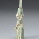 A small sculpture of the Egyptian goddess Isis with remnants of the infant body of Horus. Front view.