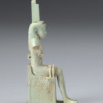 A small sculpture of the Egyptian goddess Isis with remnants of the infant body of Horus. Side view.