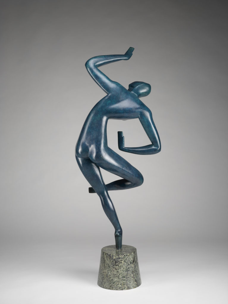 A sculpture of a blue human figure on a small stone pedestal against a gray background. The figure is standing on one leg, with the other leg bent. Its upper body is leaning to the side, with one arm bent above its head and the other arm bent at its waist. Front view.