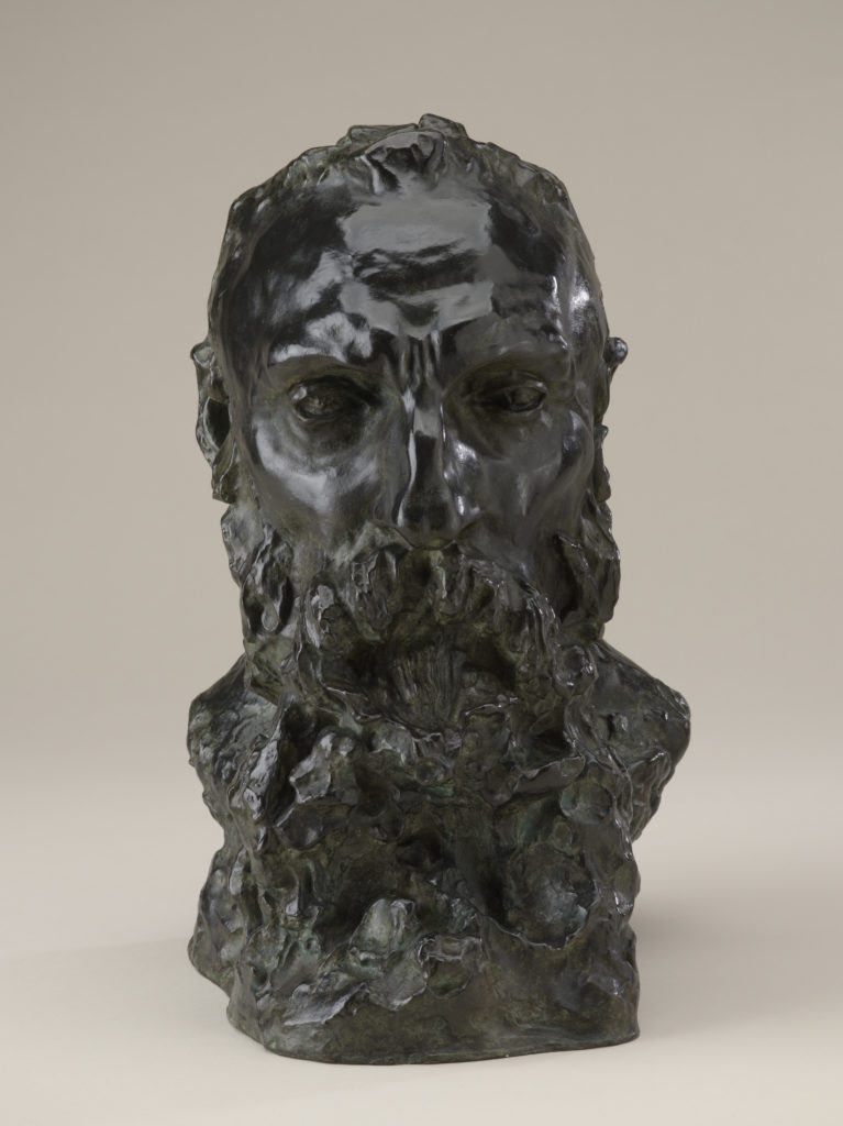 A bronze sculpture of the head, neck, and upper shoulders of a bearded man.