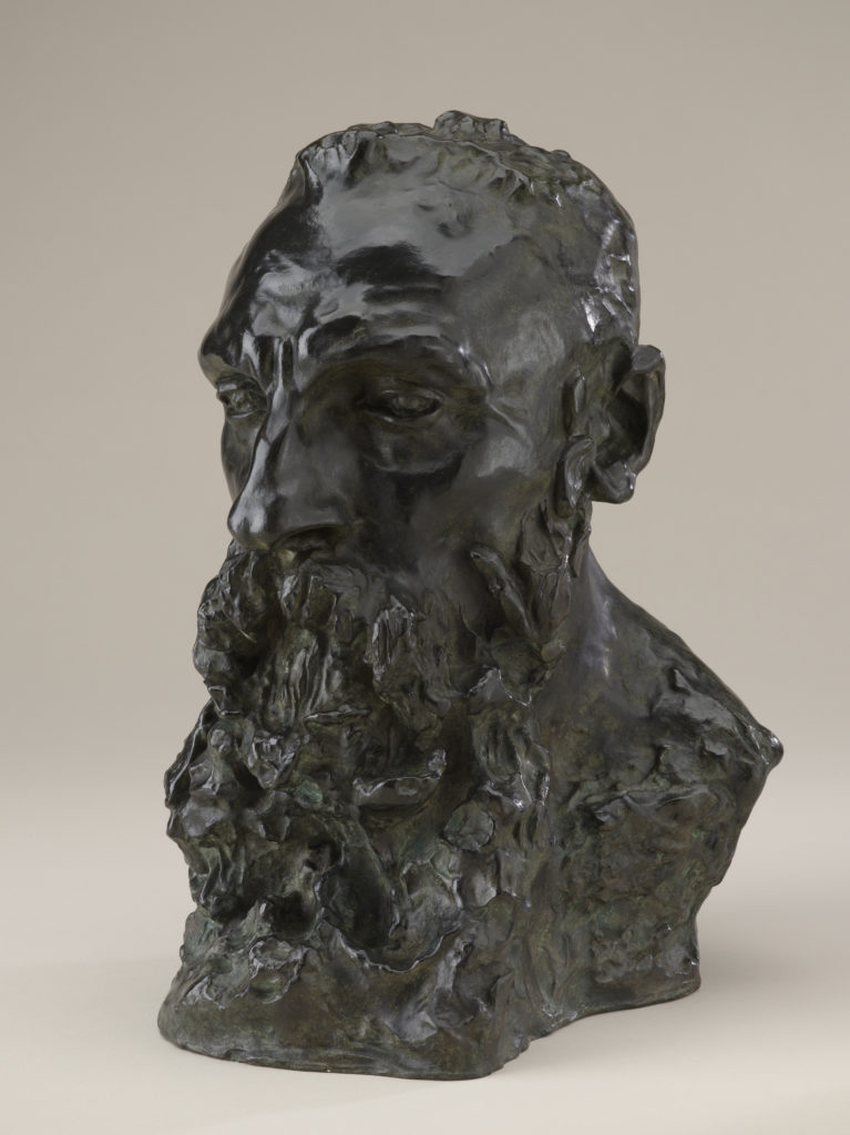 A bronze sculpture of the head, neck, and upper shoulders of a bearded man.