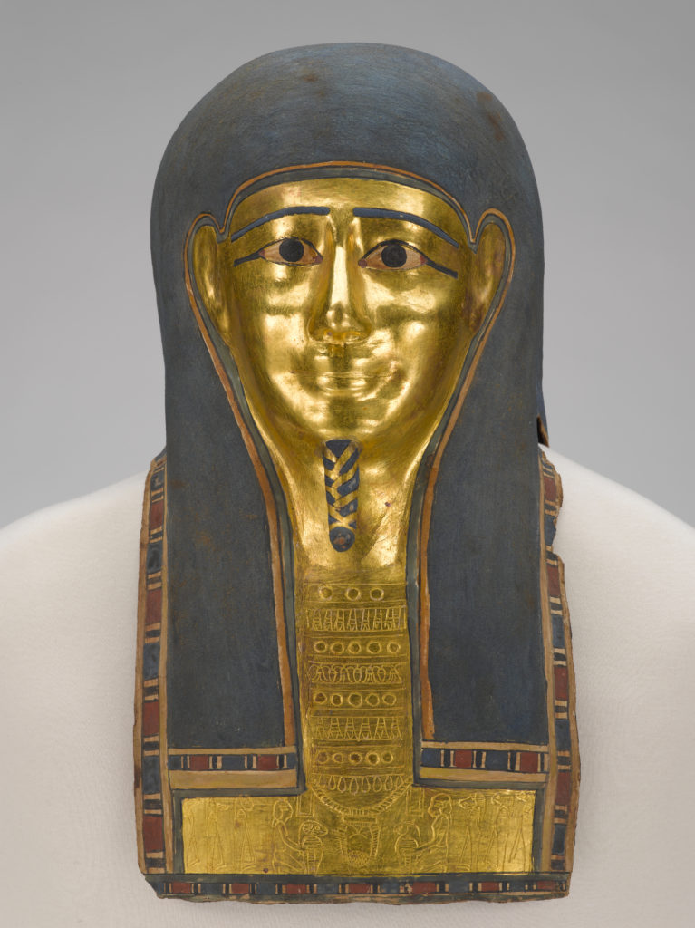 A white, linen-wrapped mummy covering with a gold Egyptian mask and gold accents on the chest, legs, and feet.