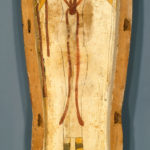 A wooden coffin shaped like a human body, with ancient Egyptian symbols and deities painted on its surface. Reverse back section.
