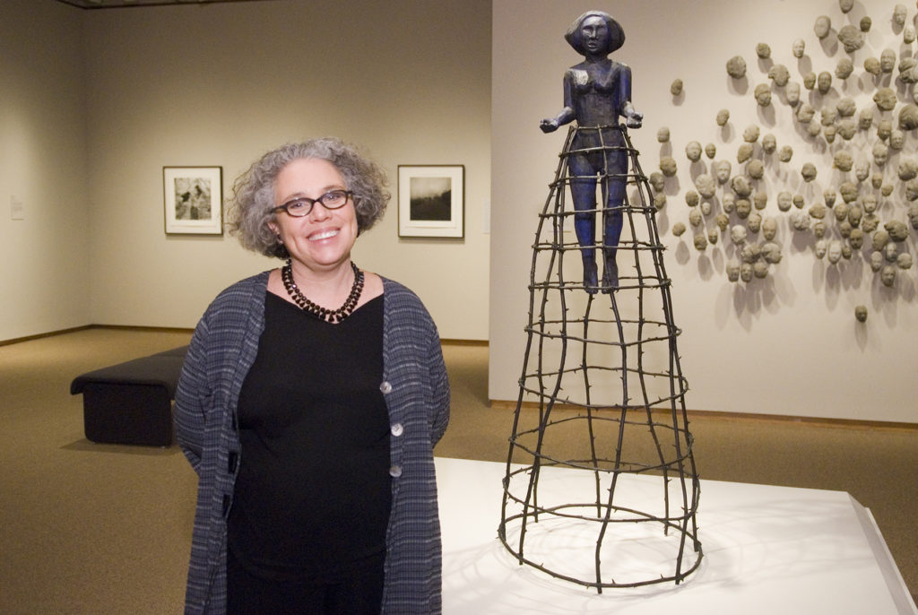 Artist Alison Saar stands next to her sculpture Tippy Toes