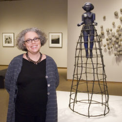 Artist Alison Saar stands next to her sculpture Tippy Toes