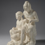 A white marble sculpture of a father and daughter sitting. The daughter sits slightly lower than the father while she works on a weaving project. Her father is carving an arrowhead. A slaughtered deer lies at their feet. Side view.