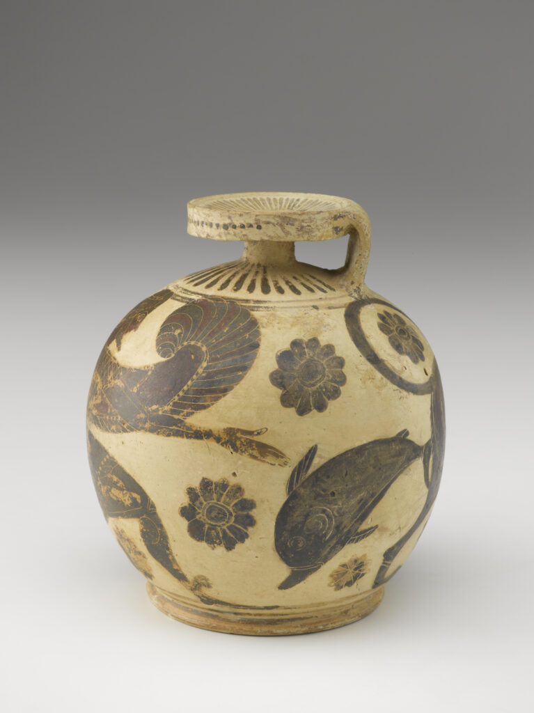 A beige-colored clay pot with a round base, a small neck, a handle, and flat mouth. It is decorated with black painted designs of flowers, a dolphin, and geometric shapes.