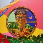 Close up of the portrait of the older woman wearing glasses.