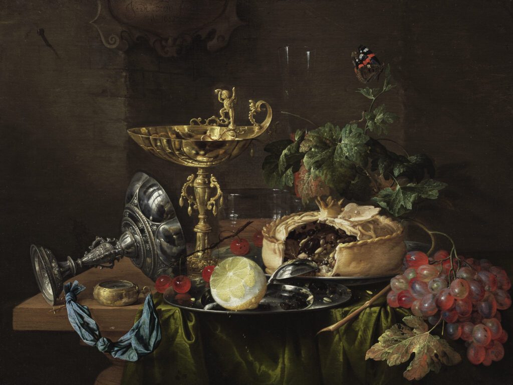 still life painting of a messy table with gruit, a meat pie, and metal chalices